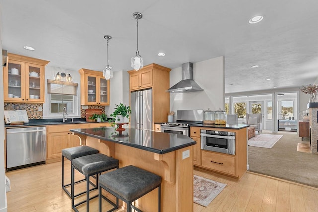 704 Fromm Ln, Elkhart Lake, WI 53020 - kitchen featuring appliances with stainless steel finishes, wall chimney range hood, dark countertops, a sink, and recessed lighting