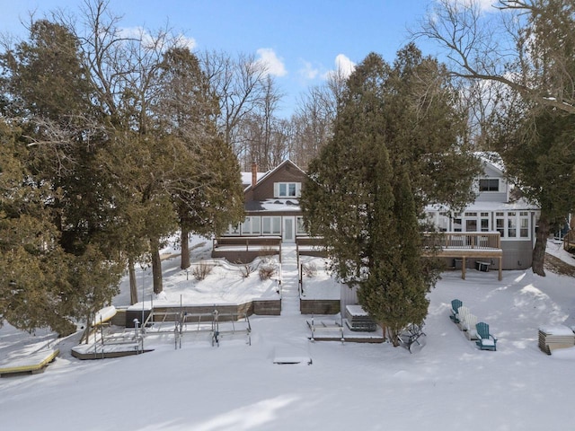 704 Fromm Ln, Elkhart Lake, WI 53020 - snow covered property with a wooden deck and a chimney