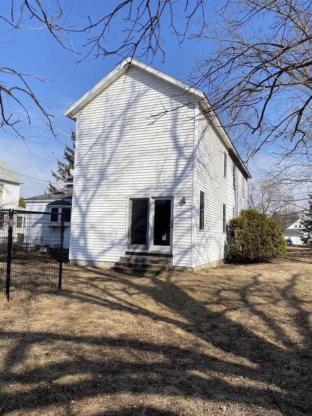 back of property with entry steps and fence