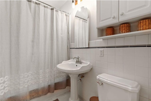 full bath featuring tile walls and toilet