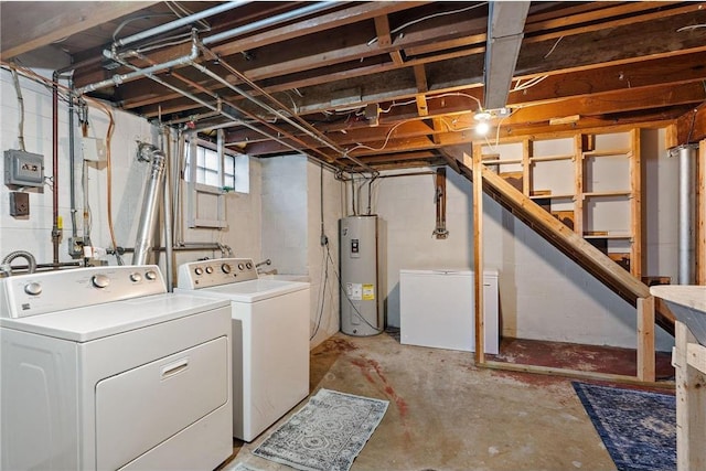 below grade area featuring fridge, water heater, stairway, and independent washer and dryer