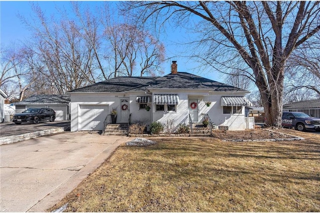 view of front facade featuring driveway, a chimney, an attached garage, a front yard, and stucco siding