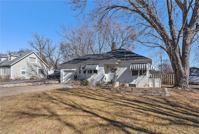 bungalow with a garage, fence, driveway, a front lawn, and a chimney