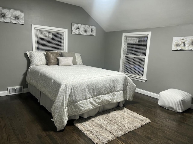 bedroom with lofted ceiling, visible vents, baseboards, and wood finished floors