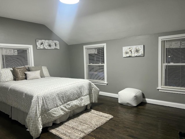 bedroom featuring lofted ceiling, wood finished floors, and baseboards