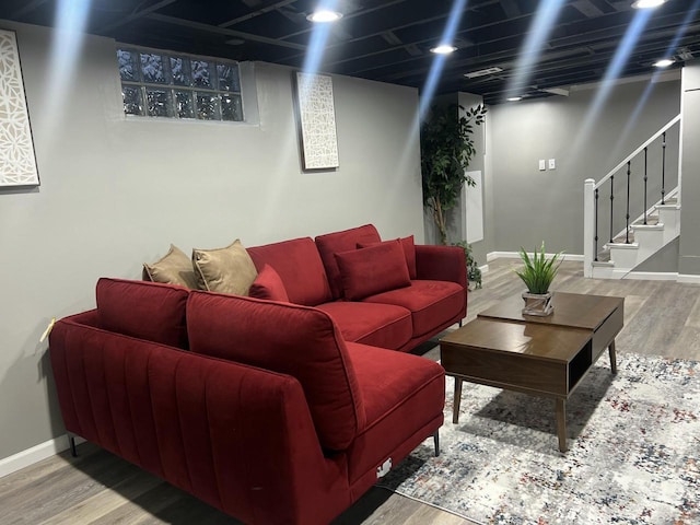 living area with stairs, baseboards, and wood finished floors