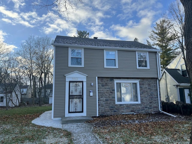 view of front of house featuring stone siding and roof with shingles