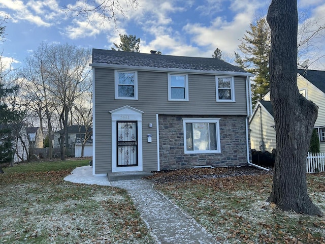 view of front facade featuring stone siding and fence