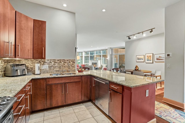 kitchen featuring dishwasher, stove, a peninsula, a sink, and backsplash