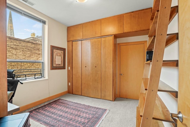 carpeted office space with a wealth of natural light, visible vents, and baseboards