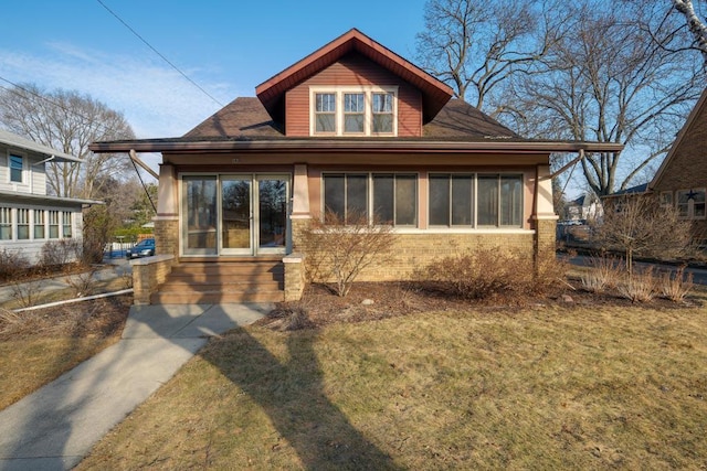 view of front of home featuring a front yard and brick siding