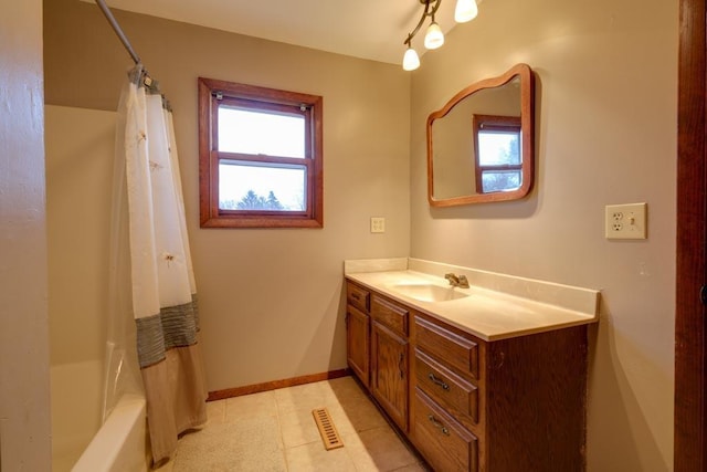 bathroom with baseboards, visible vents, shower / bath combination with curtain, and vanity