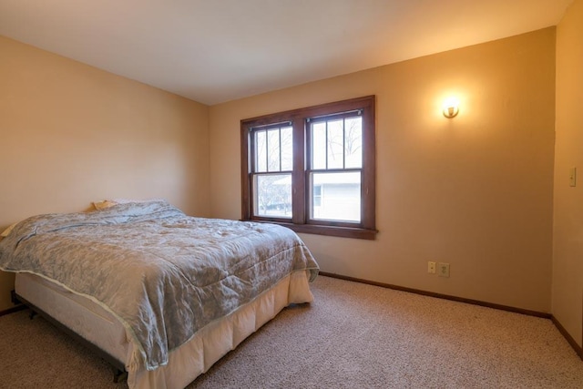 bedroom featuring light colored carpet and baseboards