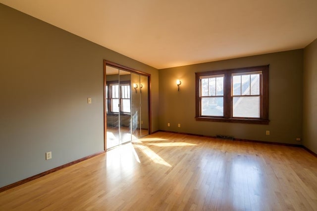 empty room featuring baseboards and light wood-style floors