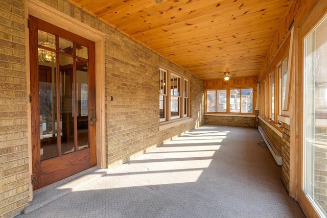 unfurnished sunroom with a baseboard radiator and wooden ceiling