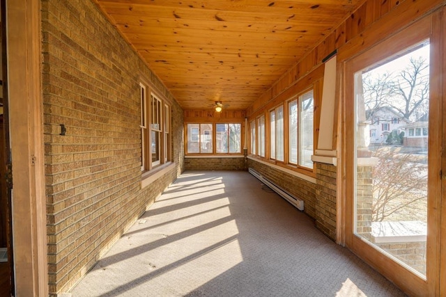 unfurnished sunroom with a wealth of natural light, wood ceiling, and baseboard heating