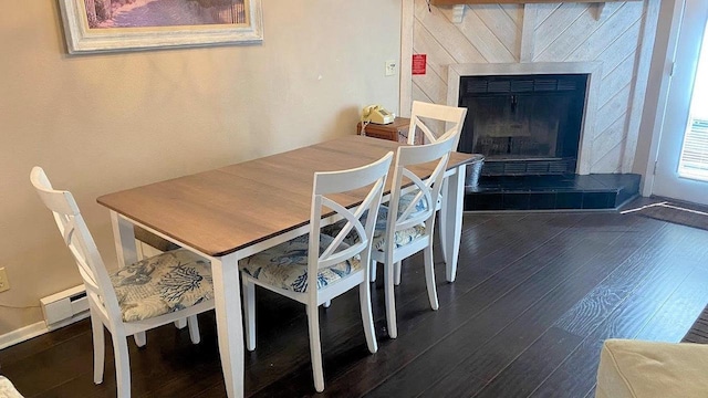 dining area with a tile fireplace, dark wood finished floors, and a baseboard radiator