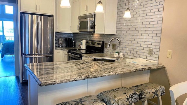 kitchen featuring appliances with stainless steel finishes, white cabinets, and decorative backsplash