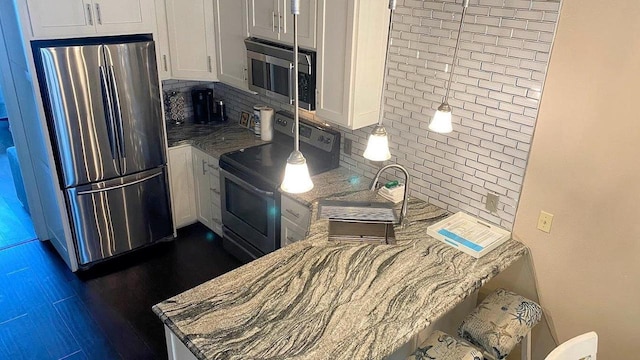 kitchen with stainless steel appliances, light stone counters, white cabinetry, and decorative backsplash