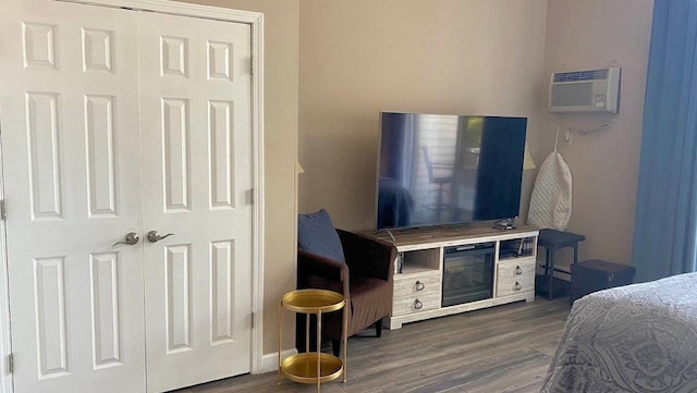 bedroom featuring a wall unit AC and wood finished floors