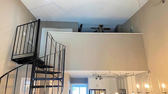 stairs featuring ceiling fan