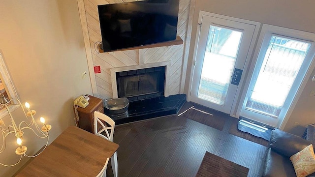 living room featuring a fireplace with raised hearth and wood finished floors