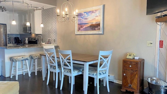 dining space featuring a chandelier and dark wood-style flooring