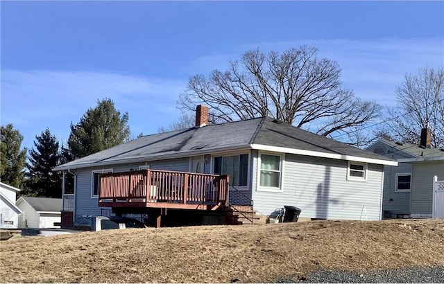 rear view of house with a chimney and a wooden deck