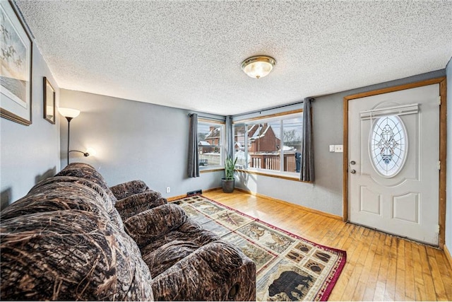 entryway featuring a textured ceiling, baseboards, and hardwood / wood-style floors