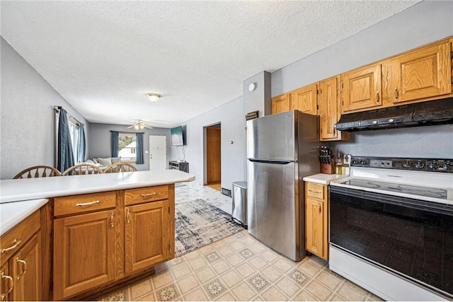 kitchen with light floors, light countertops, electric range, freestanding refrigerator, and under cabinet range hood