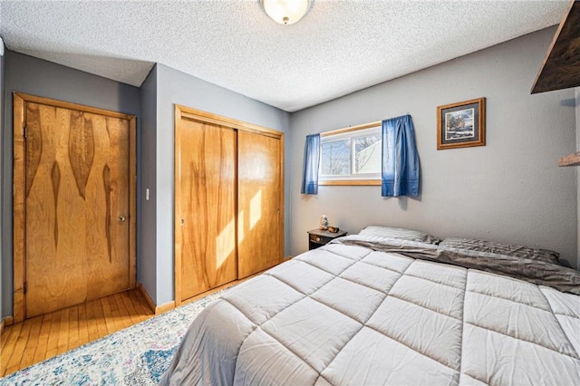 bedroom featuring hardwood / wood-style flooring, a textured ceiling, and a closet