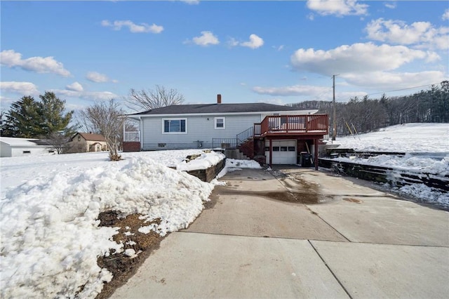 view of front of house featuring concrete driveway, an attached garage, and a wooden deck