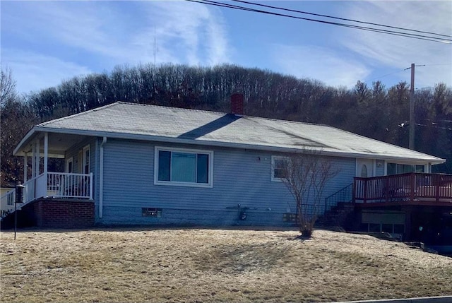 view of home's exterior featuring covered porch, a chimney, and stairs