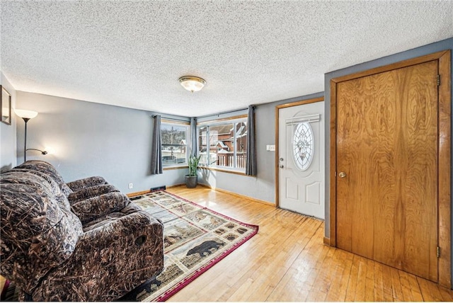 entryway featuring hardwood / wood-style flooring, baseboards, and a textured ceiling