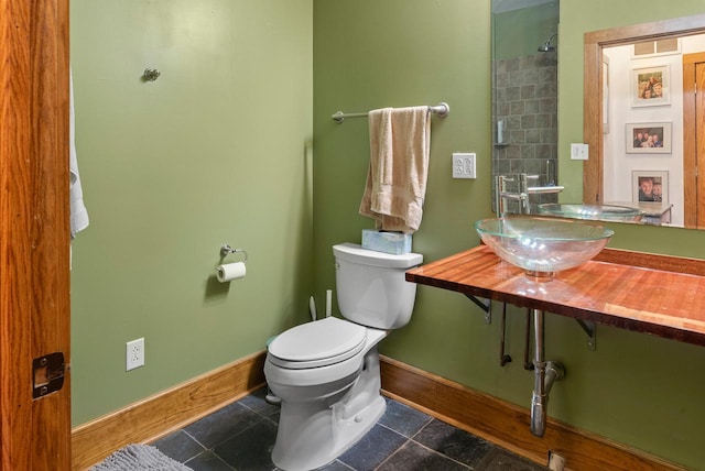 bathroom featuring a sink, toilet, and baseboards