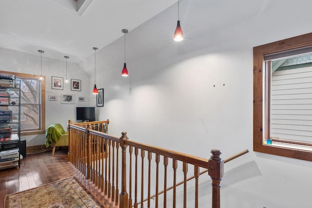 corridor featuring vaulted ceiling, wood finished floors, and an upstairs landing