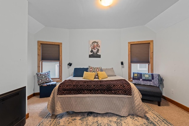 carpeted bedroom featuring vaulted ceiling and baseboards