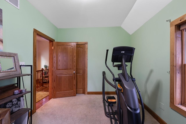 exercise room with lofted ceiling, baseboards, visible vents, and carpet