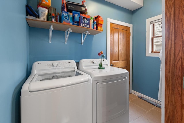 clothes washing area with light tile patterned floors, laundry area, independent washer and dryer, and baseboards