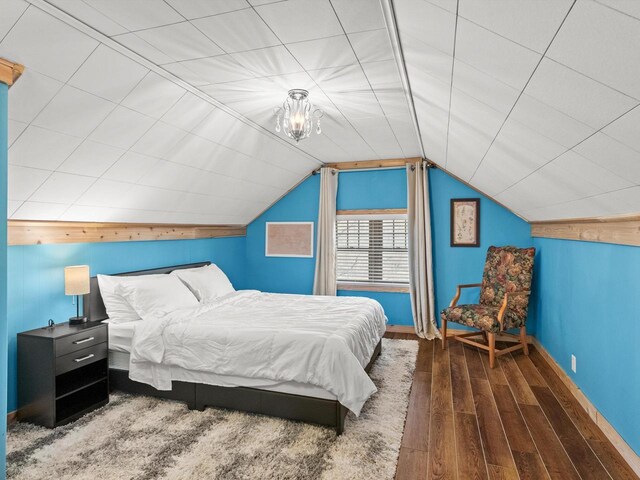 bedroom featuring baseboards, vaulted ceiling, and wood finished floors