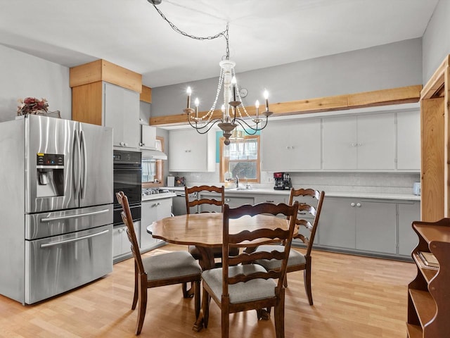 dining room featuring light wood-type flooring and an inviting chandelier