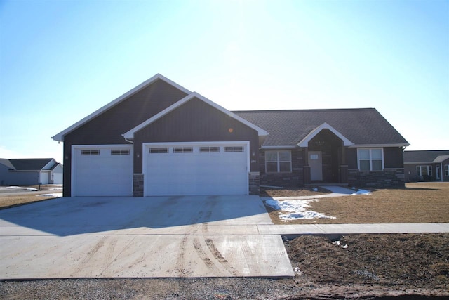 view of front of home with a garage, concrete driveway, and stone siding