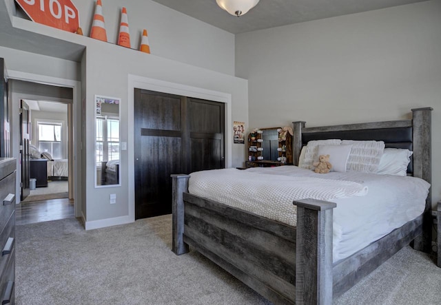 carpeted bedroom with baseboards and a closet