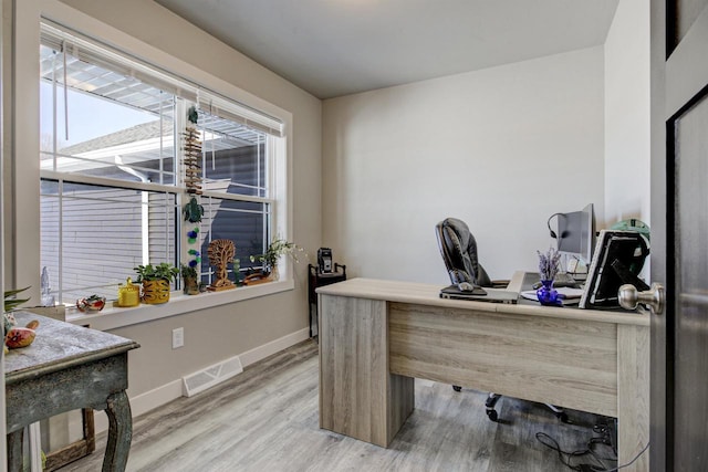 home office featuring light wood finished floors, baseboards, and visible vents