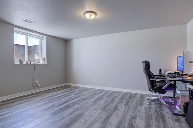 office space featuring visible vents, baseboards, and wood finished floors