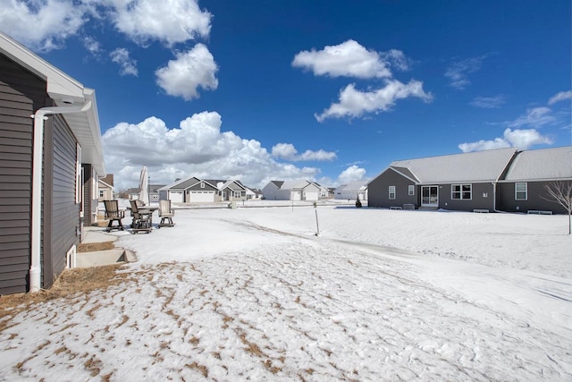 yard covered in snow featuring a residential view