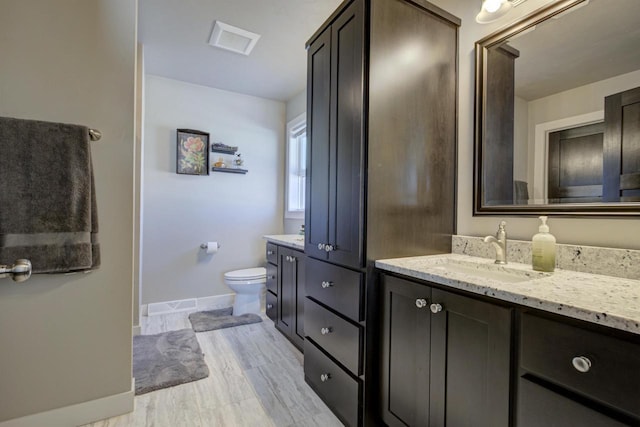 full bathroom featuring toilet, visible vents, vanity, and baseboards