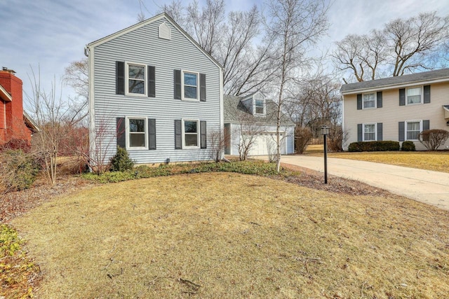 view of front facade with concrete driveway, an attached garage, and a front yard