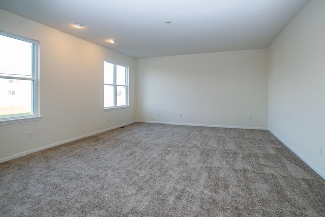 carpeted spare room featuring baseboards