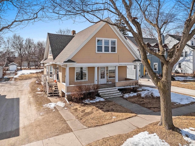 view of front of home featuring a porch, roof with shingles, and a chimney